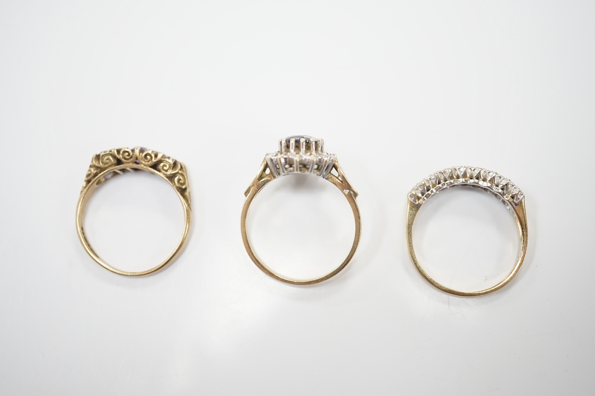 Three assorted 9ct and gem set rings including a diamond chip cluster half hoop and two pairs of yellow metal and gem set ear studs including sapphire? and diamond cluster. Condition - fair to good